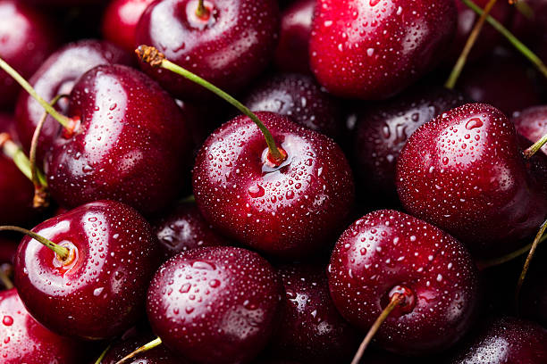 Fresh ripe black cherries on a blue stone background Top view Close up.